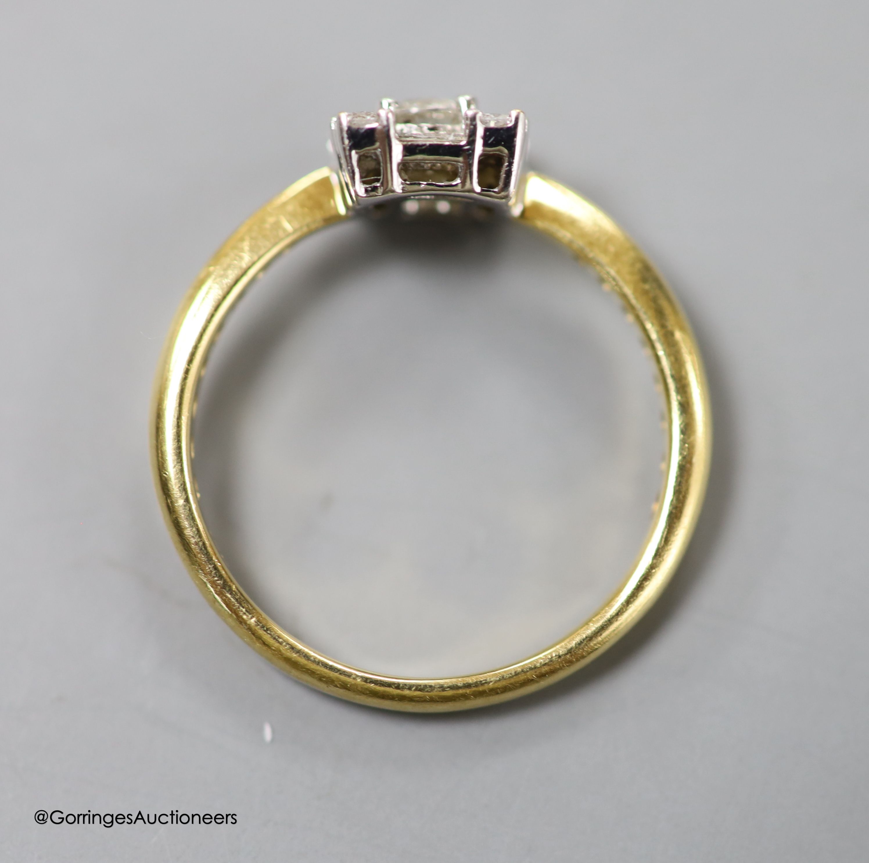 A modern 18ct gold, round and baguette cut diamond set square cluster ring, size N, gross 2.8 grams.